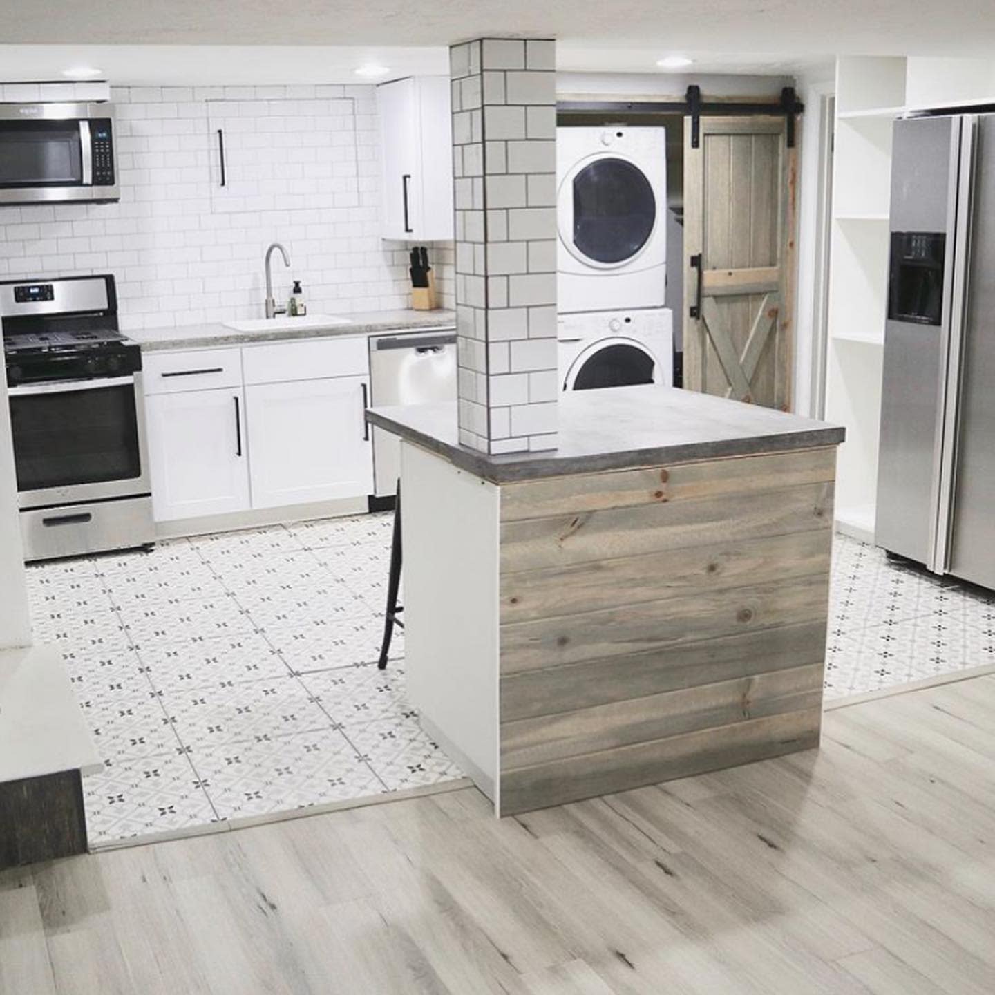 Modern kitchen with subway tile, stainless steel appliances, and adjacent laundry area.